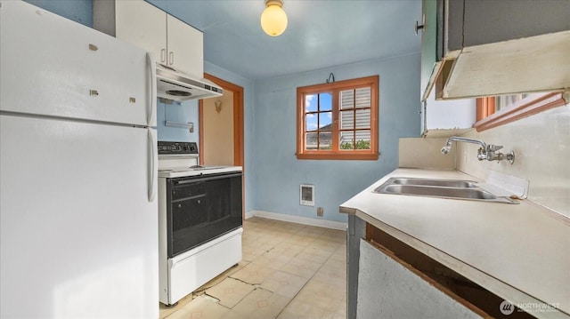 kitchen featuring under cabinet range hood, a sink, electric range oven, freestanding refrigerator, and light countertops