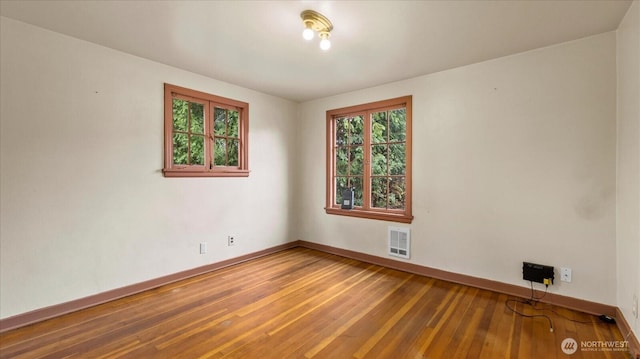 unfurnished room with hardwood / wood-style floors and baseboards