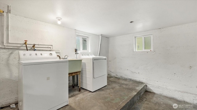 laundry area featuring separate washer and dryer and a sink