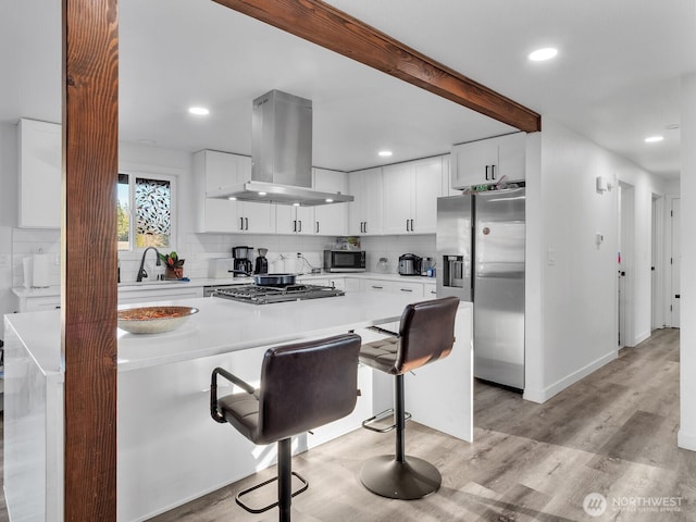 kitchen with stainless steel fridge with ice dispenser, backsplash, a sink, island exhaust hood, and beam ceiling