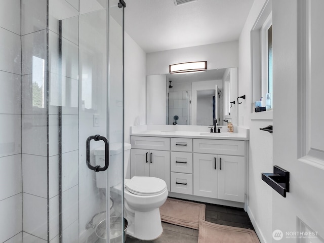 full bathroom featuring toilet, a stall shower, and vanity