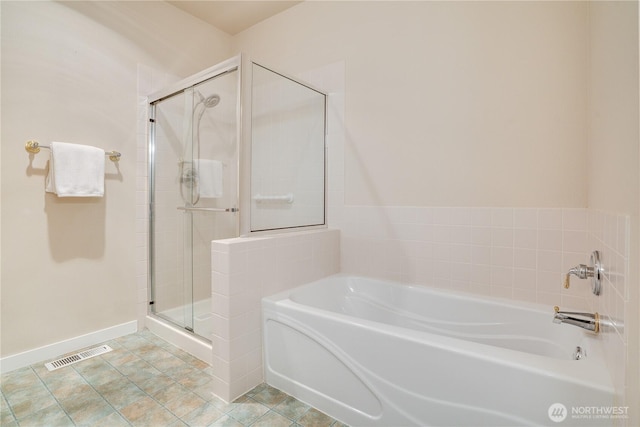 bathroom with a shower stall, a bath, baseboards, and visible vents