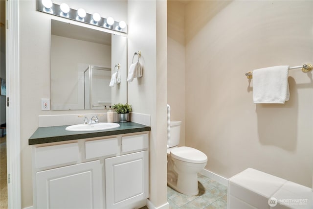 bathroom featuring tile patterned floors, an enclosed shower, toilet, and vanity