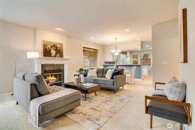 living room featuring baseboards, a tiled fireplace, light colored carpet, recessed lighting, and a notable chandelier