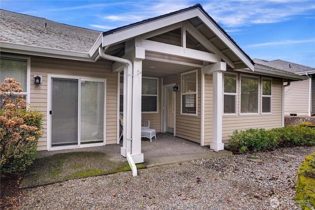 doorway to property featuring a shingled roof