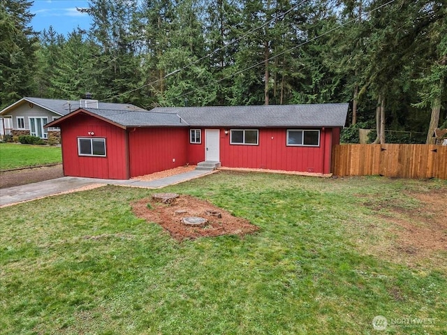 single story home featuring entry steps, driveway, fence, and a front yard