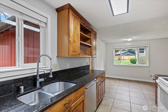 kitchen with light tile patterned flooring, a sink, white range with electric stovetop, brown cabinets, and dishwasher