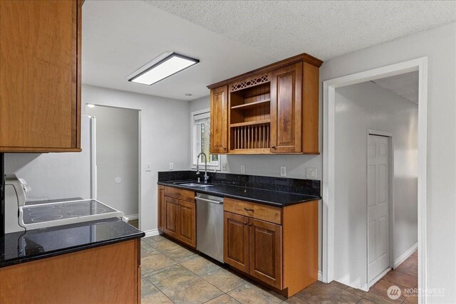 kitchen with a textured ceiling, a sink, baseboards, stainless steel dishwasher, and open shelves