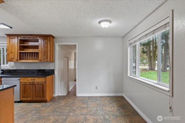 kitchen featuring brown cabinets, dishwasher, baseboards, and open shelves