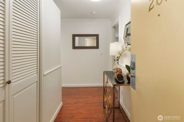 corridor featuring baseboards, dark wood-style floors, and crown molding