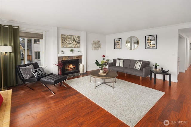 living area with hardwood / wood-style floors, a fireplace, and ornamental molding