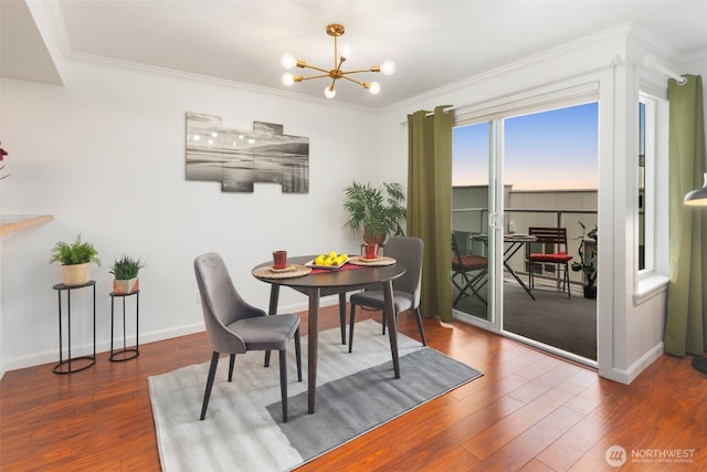 dining area with baseboards, crown molding, an inviting chandelier, and wood finished floors