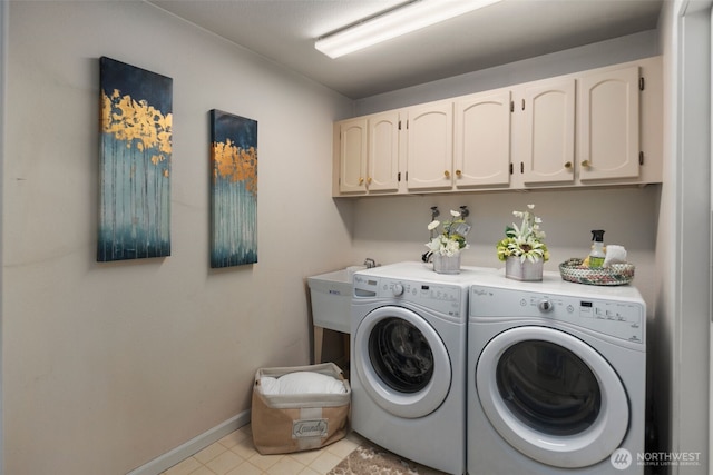 washroom featuring baseboards, washing machine and dryer, light tile patterned floors, cabinet space, and a sink