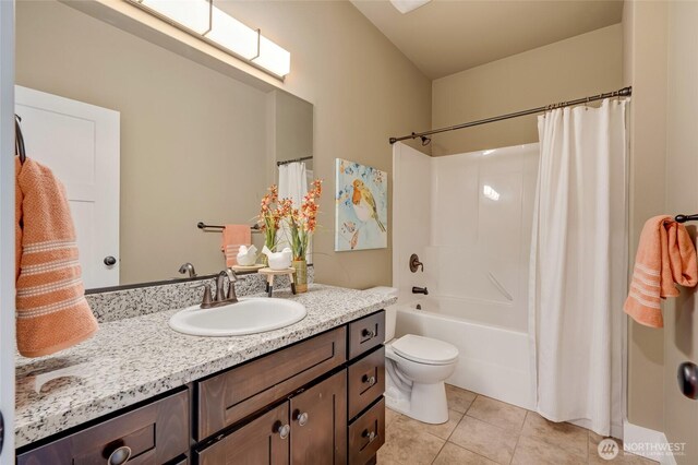 bathroom featuring toilet, tile patterned flooring, shower / bath combo with shower curtain, and vanity