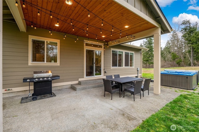 view of patio / terrace with a hot tub, outdoor dining area, and area for grilling