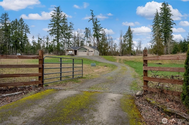 view of gate featuring a yard, fence, and a rural view