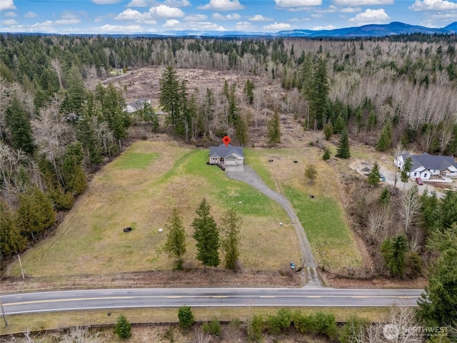 birds eye view of property featuring a forest view and a mountain view