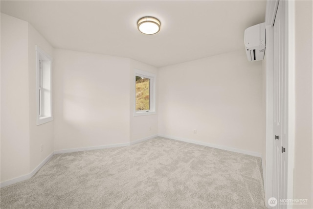 empty room featuring carpet floors, a wall unit AC, and baseboards