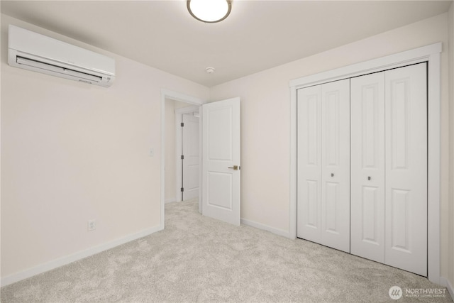 unfurnished bedroom with carpet, a closet, a wall unit AC, and baseboards