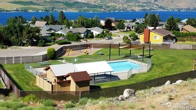 pool with a yard, fence, and a residential view