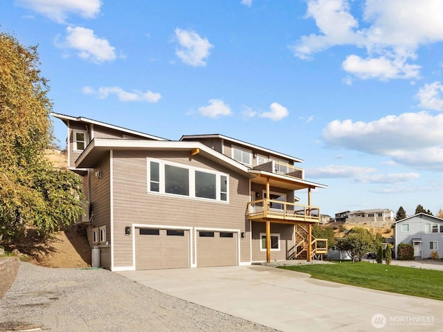 view of front of home featuring driveway, a balcony, an attached garage, stairs, and a front yard