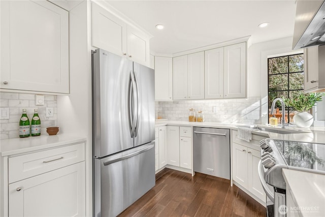 kitchen featuring stainless steel appliances, dark wood-style flooring, and white cabinets