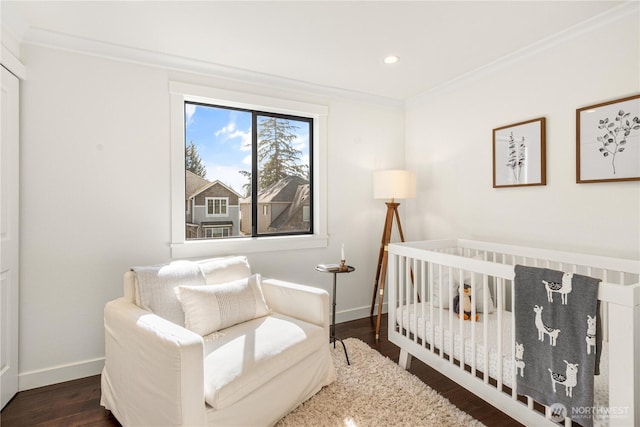 bedroom featuring baseboards, dark wood finished floors, and crown molding