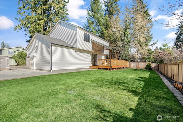 back of property with a fenced backyard, a wooden deck, and a yard