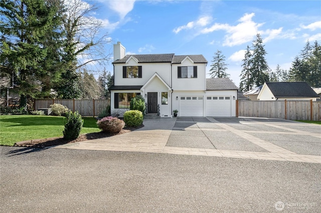 view of front of home featuring concrete driveway, a chimney, a front yard, and fence