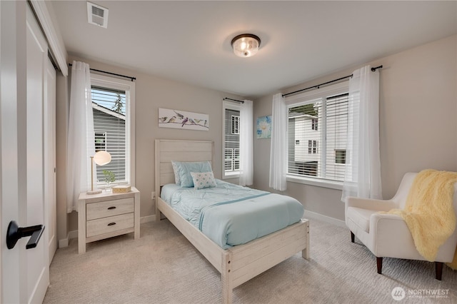 bedroom with baseboards, visible vents, and light carpet