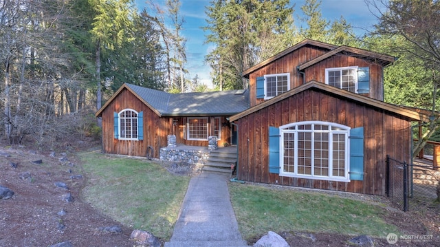 rustic home with a front lawn and roof with shingles