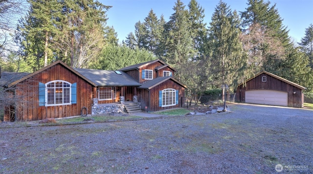 chalet / cabin with a garage and an outbuilding