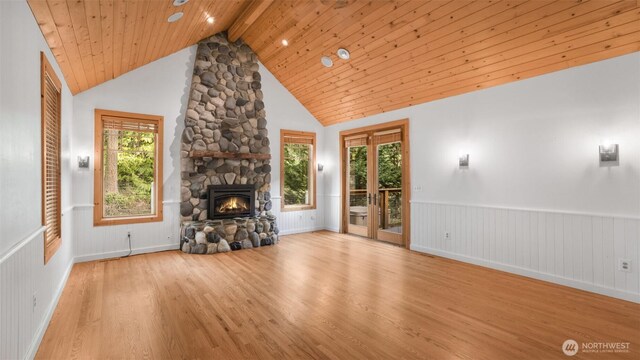 unfurnished living room featuring a fireplace, wainscoting, wood finished floors, wooden ceiling, and beamed ceiling