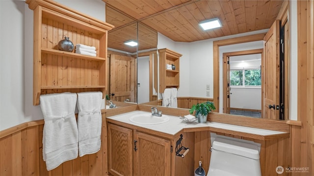 bathroom with wood ceiling, a wainscoted wall, wooden walls, and toilet