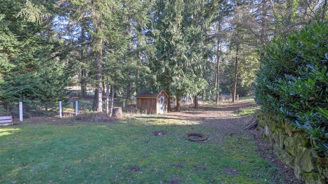 view of yard with an outdoor structure, a storage shed, and fence