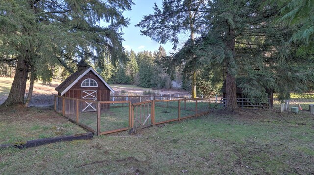 view of outbuilding with an outdoor structure, fence, and a gate