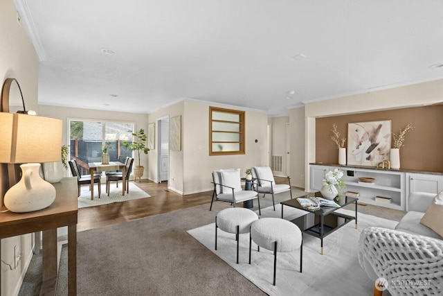 living area featuring baseboards, wood finished floors, and crown molding