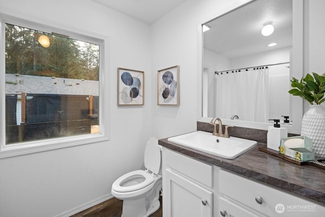 bathroom with baseboards, toilet, wood finished floors, curtained shower, and vanity