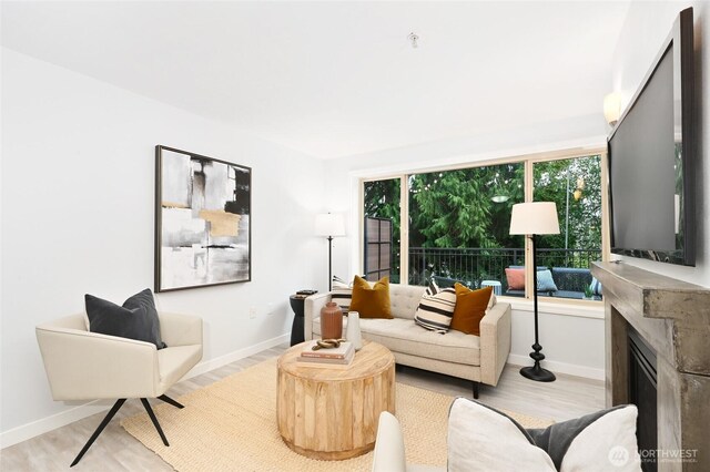 living area with light wood-type flooring and baseboards