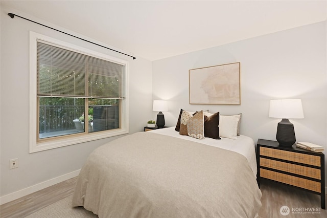 bedroom with baseboards and wood finished floors