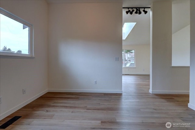 spare room with visible vents, baseboards, and wood finished floors