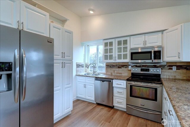 kitchen with white cabinetry, backsplash, appliances with stainless steel finishes, and a sink