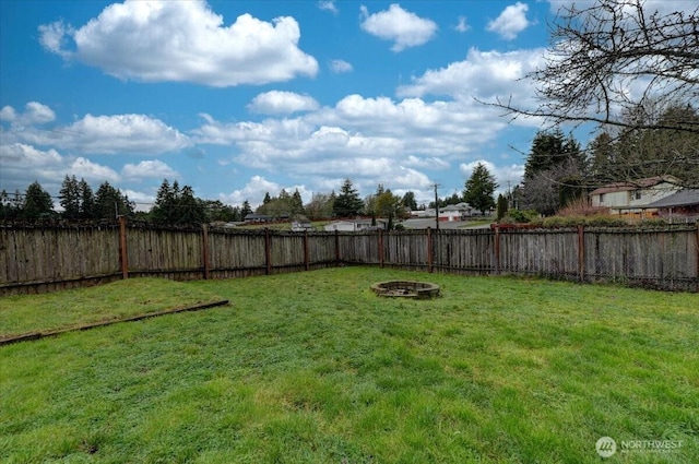 view of yard with a fenced backyard and an outdoor fire pit