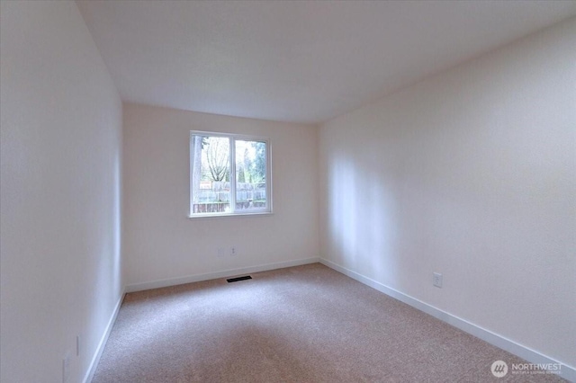 carpeted empty room featuring visible vents and baseboards