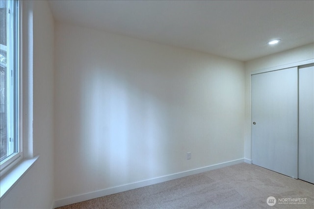 unfurnished bedroom with recessed lighting, carpet flooring, baseboards, and a closet