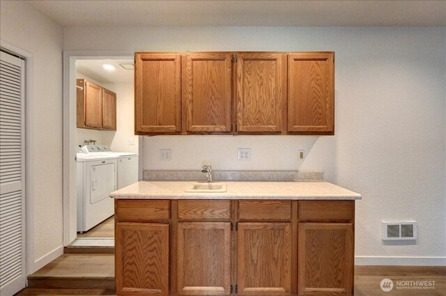 kitchen featuring a sink, visible vents, separate washer and dryer, and light countertops