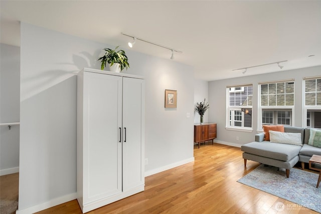 sitting room featuring baseboards and light wood-style floors