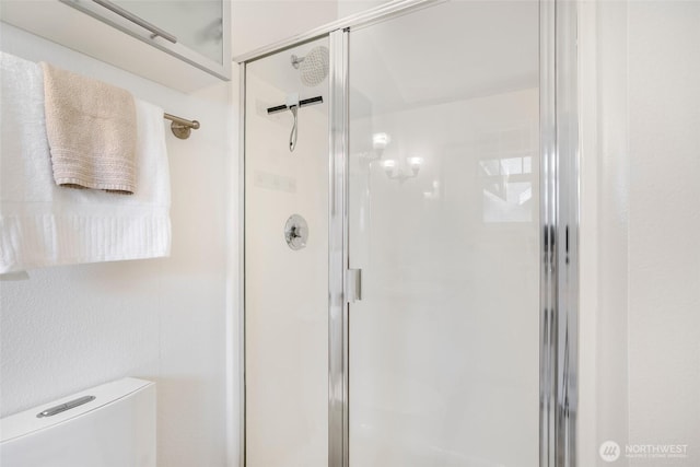 full bath featuring a stall shower and toilet