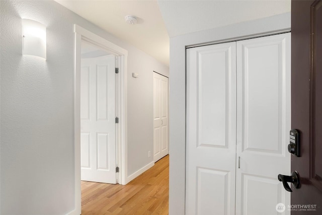 hallway featuring light wood-style floors and baseboards