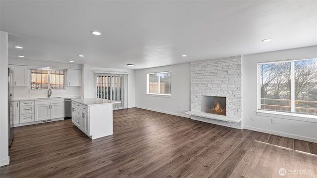 kitchen featuring dark wood-type flooring, white cabinets, plenty of natural light, and stainless steel appliances